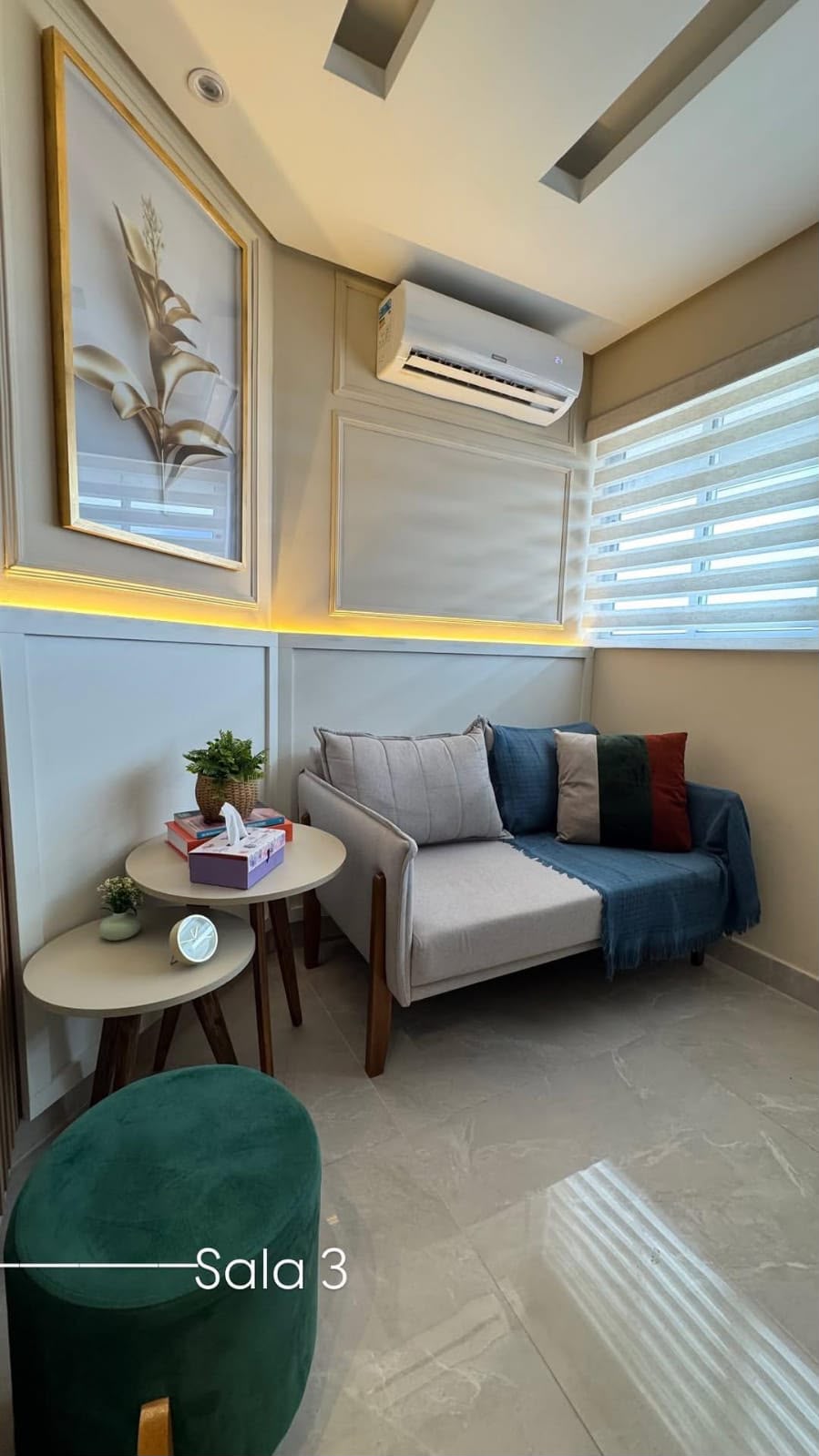 Sala 3 do consultório de Sueli Lima, com sofá claro, manta e luz indireta